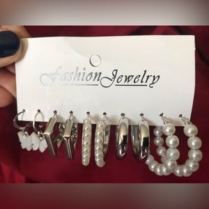 5 pair of silver tone and pearl like earrings.